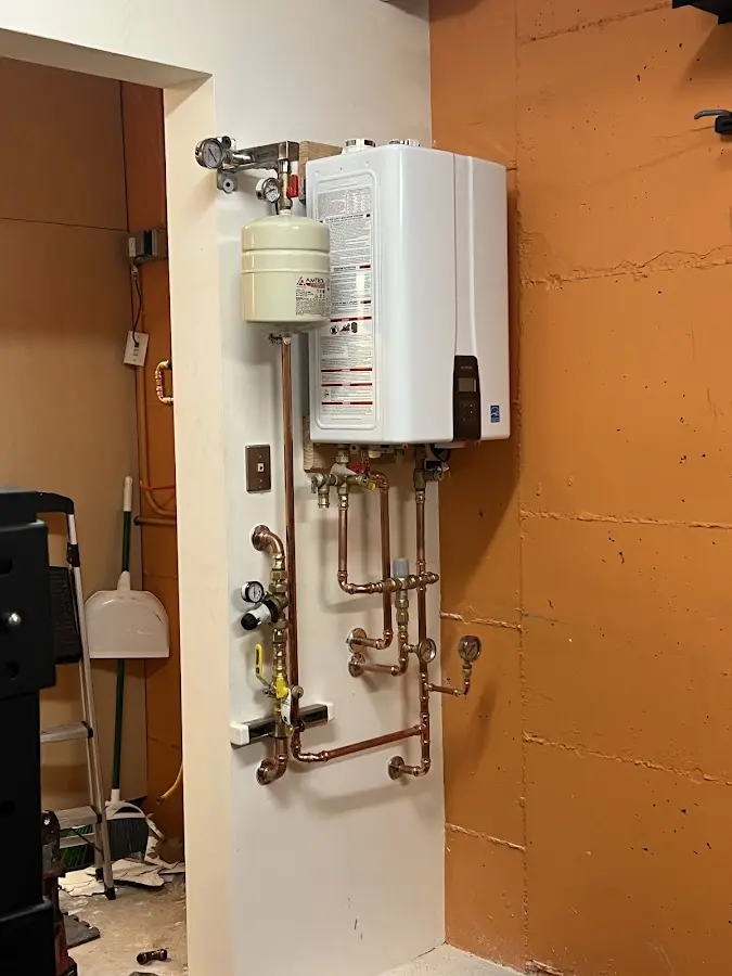 Plumbing technician inspecting water heater connections in Smithfield